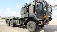 Eine LKW-Zugmaschine in Tarnfarben steht auf dem Kasernengelände