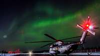 Bei Polarlicht steht die CH-53 kurz vor dem Nachtflug auf dem Rollfeld der finnischen Air Base