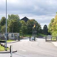 Einfahrt einer Kaserne von Bäumen umgeben