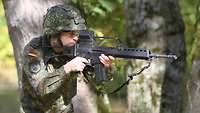 Soldat im Feldanzug mit G36 im Anschlag.