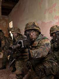 Soldaten beim Häuserkampf Bewaffnete Soldaten in einem Haus