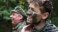 Soldat trägt Tarnschminke auf