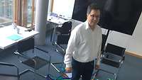 Eric Pastor steht in einem Netz aus bunten Bändern während der Ausbildung