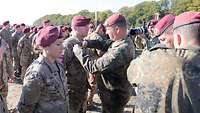 Ein Offizier steckt einem Soldaten ein Sprungabzeichen an.