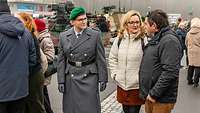 Ein Soldat geht mit seinen Angehörigen über den Ausstellungsplatz.