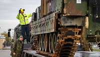 Ein Panzer fährt auf die Ladefläche eines LKW.