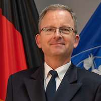 Ein Mann vor Flaggen