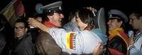 Männer umarmen sich am Tag der Deutschen Einheit in Berlin Männer mit NVA-Mützen umarmen sich