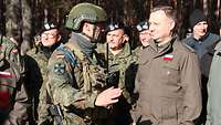 Ein Soldat und ein Zivilist sprechen miteinander.