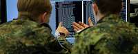 Zwei Soldaten zeigen auf einen Bildschirm