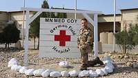 Ein Soldat kniet vor einem Schild mit der Aufschrift: German Field Hospital