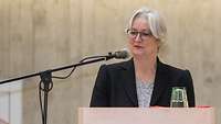Eine Frau steht an einem Rednerpult