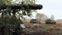 Kampfpanzer Leoprad mit zwei Waffträgern Wiesel im Hintergrund.