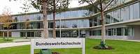 Schild mit der Aufschrift Bundeswehrfachschule vor einem verglasten Gebäude.