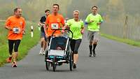 Läufer und Läuferinnen mit Kinderwagen beim Lauf 