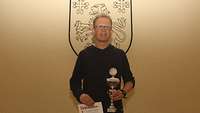 Lauritz Grote mit Pokal vor dem Regimentswappen