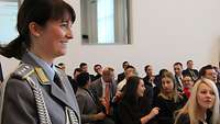 Soldatin mit mehrern Besuchern im Hintergrund.
