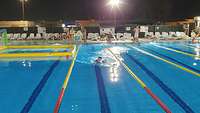 Ein Soldat schwimmt in Uniform durch ein Schwimmbecken