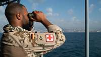Ein Soldat beobachtet mit einem Fernglas das Geschehen im Hafen von Beirut