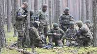 Eine Gruppe Soldaten versammelt sich im Wald
