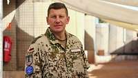 Ein deutscher Soldat steht im Vordergrund. Im Hintergrund befinden sich Munitionslagerorte