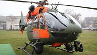 Ein stehender Hubschrauber mit leuchtend roten Flächen und dem Schriftzug SAR.