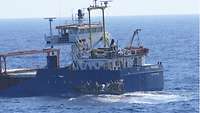 Ein Speedboot mit mehreren Soldaten nähert sich dem Frachtschiff „Spirit“ an