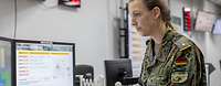 Eine Soldatn in einem Raum voller Bildschirme
