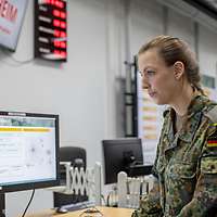 Eine Soldatn in einem Raum voller Bildschirme