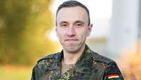 Ein jüngerer Soldat in Uniform schaut in die Kamera.