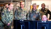 Mehrere Soldaten stehen um einen PC herum, an dem ein Mann sitzt.