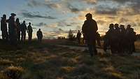 Soldaten stehen auf einem Hügel in der Abenddämmerung