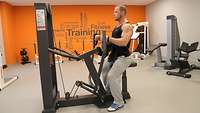 Ein Soldat in Sportkleidung trainiert auf einem Fitnessgerät seinen Oberkörper.
