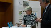 Eine Frau und ein Mann beschäftigen sich miteinem Tablet.