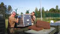 Soldaten laden in Ämari Container ab, die Material zur Vorbereitung von Treibstoffanalysen enthalten