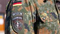 Der Arm eines deutschen Soldaten mit dem Patch der NATO – Mission KFOR