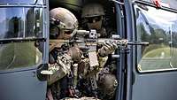 Zwei Soldaten sitzen in einem Hubschrauber.