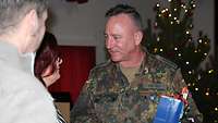 Angehörige überreichen einem Soldaten ein Weihnachtsgeschenk.