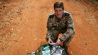 Ein Soldat kniet vor seinem geöffneten Sanitätsrucksack