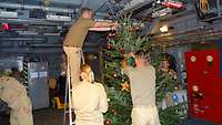 Mehrere Soldaten schmücken einen Tannenbaum