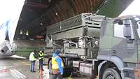 Lufttransport des Radars Ein Lkw mit einem RAT 31DL/M steht vor der geöffneten Ladeklappe eines Transportflugzeugs.