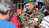 Soldat im Gespräch mit zivilen Gästen bei einem Tag der offenen Tür.