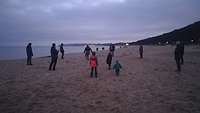Spiel und Spaß am Strand in der Dämmerung