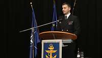 Ein Marinesoldat steht hinter einem Rednerpult