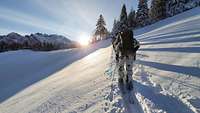 An einem tief verschneiten Hang bahnen sich mehrere Soldaten mit ihren Skiern hintereinander.