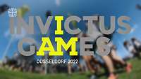 Schriftzug „Invictus Games 2022“, im Hintergrund ein unscharfes Bild von laufenden Menschen 