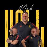 Ein Soldat in einem Sportanzug steht vor einem Plakat.