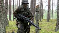 Eine Soldatin mit Maschinengewehr rennt durch den Wald