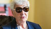 Eine ältere Frau mit Sonnenbrille im Porträt