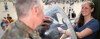 Ein Soldat im Gespräch mit einer Besucherin am Tag der Bundeswehr Ein Soldat spricht mit einer Frau, die im Cockpit eines Flugzeuges sitzt
